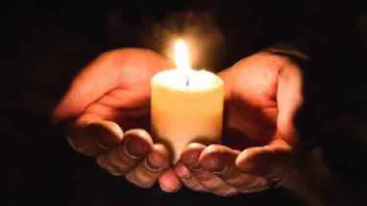 A candle held in cupped hands